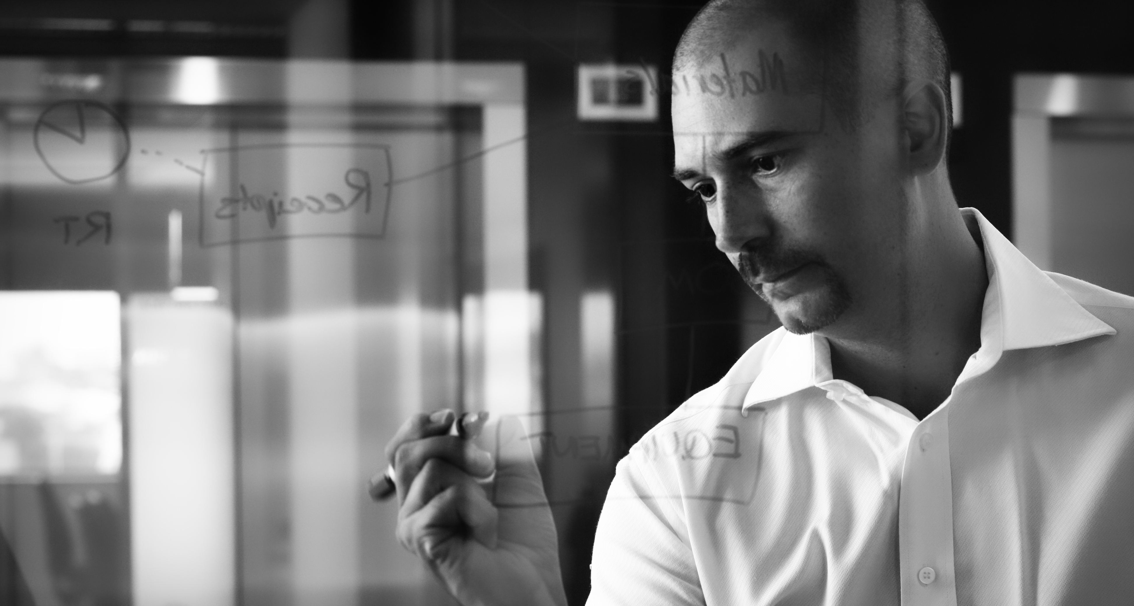 Carlos Fairgray writing on a glass wall